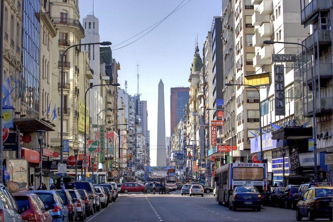 Busy Buenos Aires street with tall buildings lining both sides,
